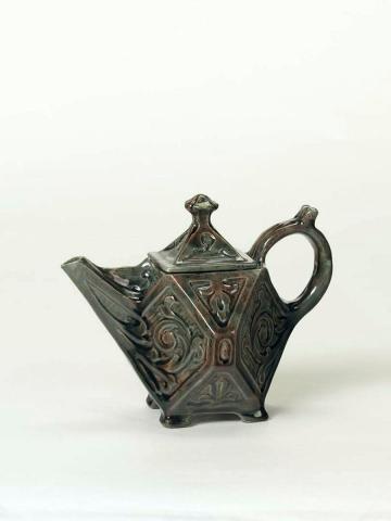 Artwork Teapot this artwork made of Slab built earthenware, hexagonal shape carved with foliate motifs and glazed mottled green and red, created in 1932-01-01