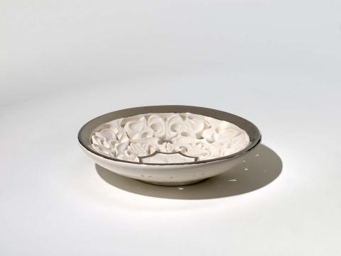 Artwork Pierced dish this artwork made of Earthenware, hand-built buff clay elaborately pierced with formalised leaf motifs with white glaze and platinum lustre, created in 1958-01-01