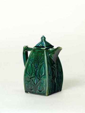 Artwork Coffeepot this artwork made of Earthenware, hand and slab built with carved and floral motifs under dark blue/green glaze, created in 1935-01-01