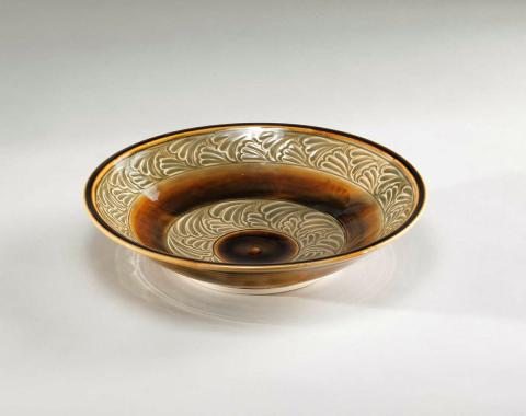 Artwork Bowl this artwork made of Porcelain, wheelthrown, carved motifs with celadon glaze and iron brushed bands, created in 1994-01-01