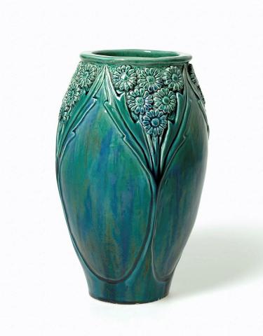 Artwork Daisy vase this artwork made of Earthenware, hand-built swelling cylindrical form carved with daisy and leaf motif, glazed green and blue, created in 1930-01-01