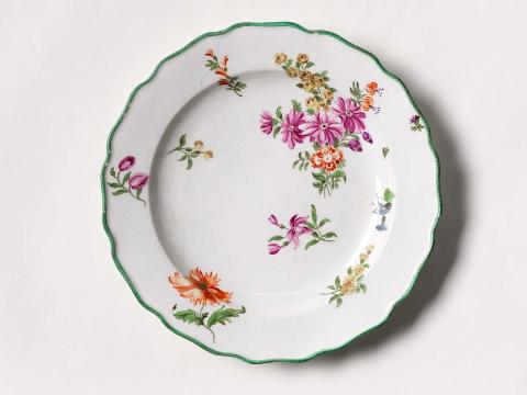 Artwork Twelve-lobed plate this artwork made of Soft-paste porcelain, decorated with polychrome floral sprays and sprigs in overglaze colours, edged in green