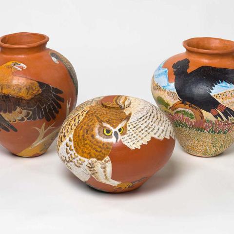 Three earthenware pots by Judith Pungkarta Inkamala with eagles and owls painted on them.