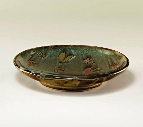 Artwork Dish with landscape decoration this artwork made of Stoneware, wheelthrown with iron oxide glaze and poured limestone and trailed celadon glazes over wax resist