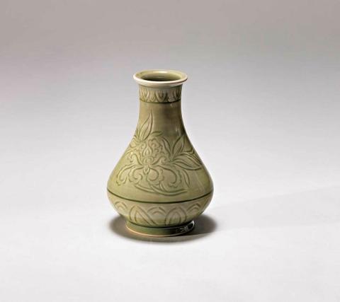 Artwork Bottle this artwork made of Porcelain, wheelthrown and carved with stiff leaves and floral motif beneath celadon glaze