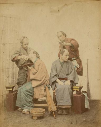 Artwork (Barbers) (from 'Japan' album) this artwork made of Hand-coloured albumen photograph on board (originally bound in an album), created in 1867-01-01