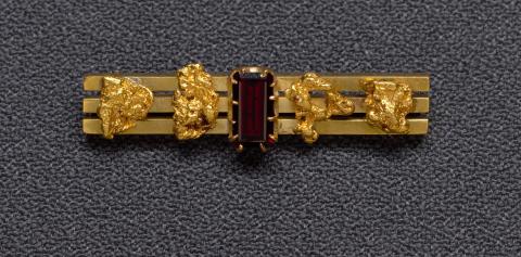 Artwork Goldfields bar brooch (three bars with four nuggets and garnet) this artwork made of Gold, gold nuggets and garnet, created in 1880-01-01