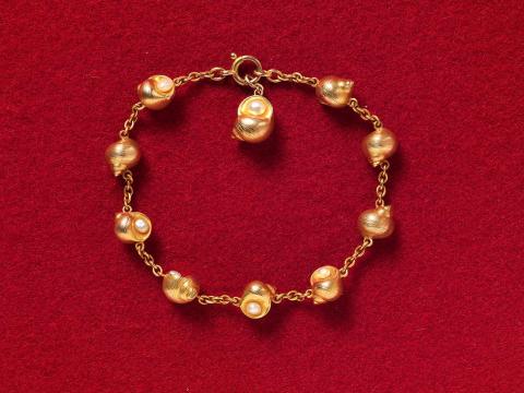 Artwork Bracelet this artwork made of Australian gold with nine linked shells, each set with a pearl, with similar detachable pendant