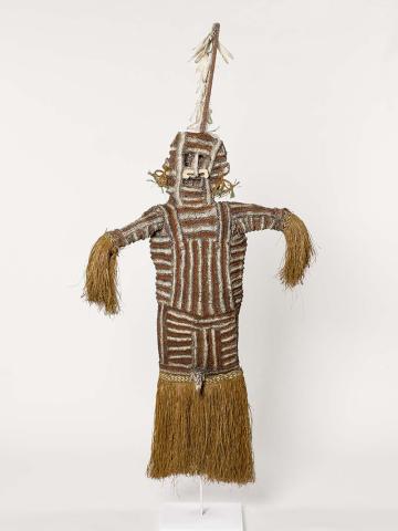 Artwork Jipai (mask) this artwork made of Shredded sago leaf, knotted fum (paper mulberry), stick, white cockatoo feathers, natural pigments (lime, ochre, charcoal), rattan earrings, shell nose-piece, pandanus decorative weaving around arm and skirt bands, jobs tear seeds