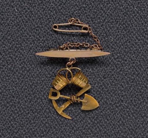 Artwork Goldfields brooch and chain (two buckets and crossed pick and shovel) this artwork made of Gold, engraved, with chain, created in 1910-01-01