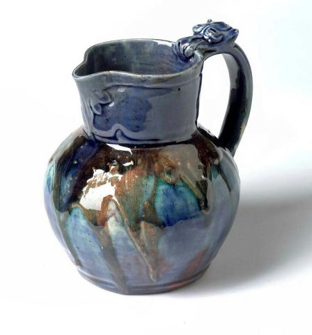 Artwork Jug this artwork made of Earthenware, dipped running clay and incised, the handle modelled as a dragon biting the rim beneath a blue glaze, created in 1920-01-01