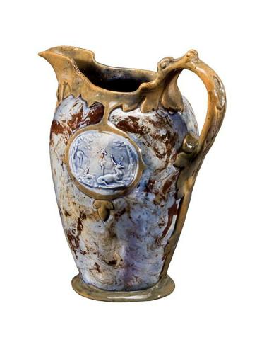 Artwork Ovoid jug this artwork made of Earthenware, two colour clays with gold slip and two inlaid cameos of reindeers and long-tongued dragon handle. Blue glaze, created in 1920-01-01