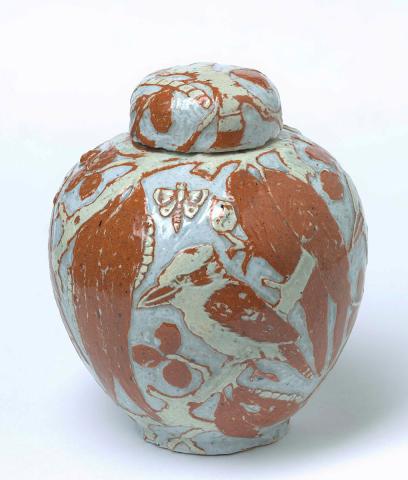 Artwork Covered jar: Kookaburras this artwork made of Earthenware, cream and terracotta clay over white and incised with a design of kookaburras and gum leaves. Light blue glaze, created in 1929-01-01
