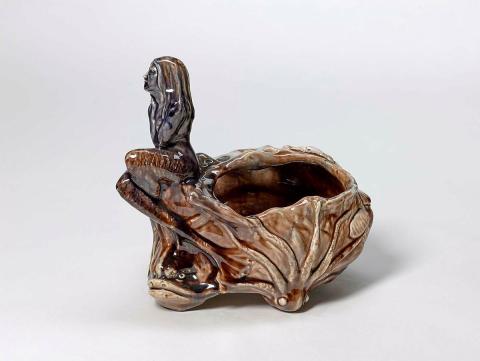 Artwork Vase: The Rock this artwork made of Earthenware, modelled with figure of a mermaid beside a rock pool with octopus, starfish and crab. Brown glaze with colours, created in 1930-01-01
