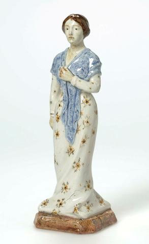 Artwork Figure: Melba this artwork made of Earthenware, modelled as a woman with shawl and mixed clay base. Polychrome details (floral patterning to dress), created in 1930-01-01