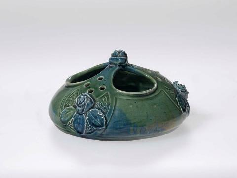 Artwork Rose bowl this artwork made of Earthenware, hand built with three apertures and modelled with four roses and leaves. Green glaze, created in 1919-01-01