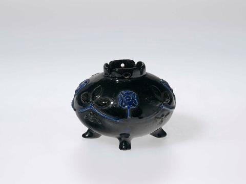 Artwork Rose bowl this artwork made of Earthenware, hand built on four feet and scalloped lip. Modelled with four formalised Tudor roses within a swag, deep cobalt blue glaze, created in 1919-01-01