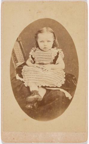 Artwork (Young girl in lace dress seated) this artwork made of Albumen photograph on paper mounted on card, created in 1872-01-01