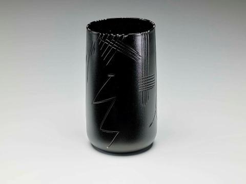 Artwork Cylinder this artwork made of Hot-worked black glass cylinder wheel cut with a reed design and semi-matt acid finish, created in 1986-01-01
