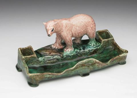 Artwork Pen tray this artwork made of Earthenware, modelled with polar bear with fish on an ice flow, and two rectangular wells, in irregular rectangular base with green glaze, created in 1920-01-01