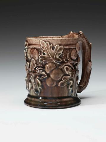 Artwork Mug this artwork made of Earthenware, hand built and carved with a design of leaves and fruit, glazed purple/brown, created in 1940-01-01