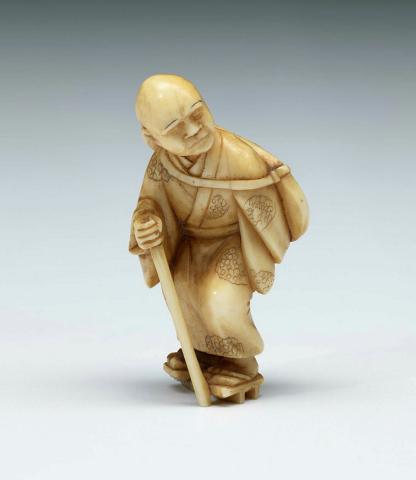 Artwork Netsuke:  (old man with walking stick) this artwork made of Ivory, carved and incised, created in 1800-01-01