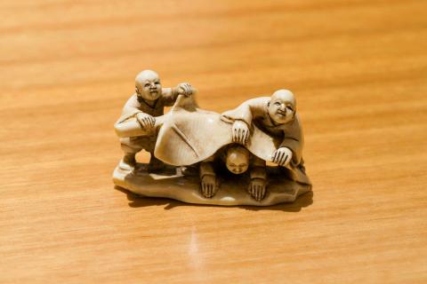 Artwork Netsuke: (children playing under lotus leaf) this artwork made of Carved ivory, created in 1895-01-01