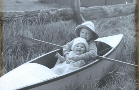 Artwork (Rosemary and Margaret in a canoe on land near a fence) this artwork made of Glass transparency, created in 1935-01-01