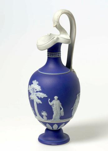 Artwork Oinoche vase:  Apollo Musagetes and the Muses Euterpe, Urania and Clio this artwork made of Porcelain (jasper ware) dark blue body dipped white and sprigged with male and female neoclassic figures, created in 1850-01-01