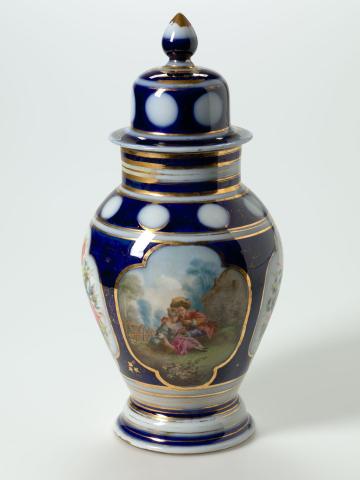 Artwork Covered vase this artwork made of Hard-paste porcelain broad baluster shape with a polychrome rococo revival and a floral panel reserved from the cobalt ground.  Gilt details (worn), created in 1860-01-01
