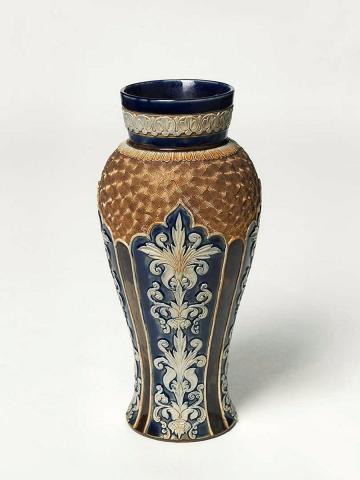 Artwork Vase this artwork made of Stoneware, baluster shape with four applied foliate panels against a blue ground separated by narrow brown panels. Gilt spiral motifs at shoulder with foliate motifs around neck. Salt glazed, created in 1891-01-01