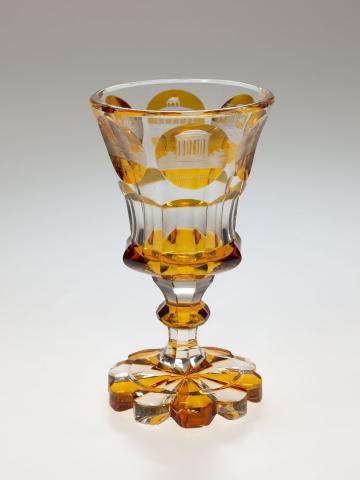 Artwork Goblet this artwork made of Clear glass flashed yellow and wheelcut with a design of classical monuments, created in 1840-01-01
