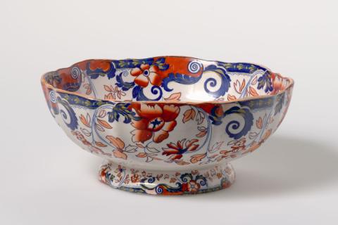 Artwork Bowl this artwork made of Stoneware, transfer-printed in blue with buildings and Japan style floral motifs with details in red and yellow with clear glaze, created in 1820-01-01