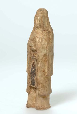 Artwork Tomb figure:  (Male figure with cloak) this artwork made of Earthenware, modelled with a degraded straw coloured glaze, created in 0581-01-01