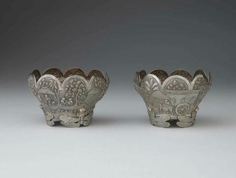 Artwork Pair of bowls this artwork made of Silver bowls with scalloped edges and repousse village scene.  Dragon fly supports, created in 1880-01-01
