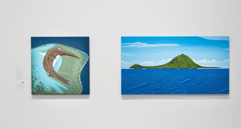 Two painted works depicting islands installed on a white gallery wall.