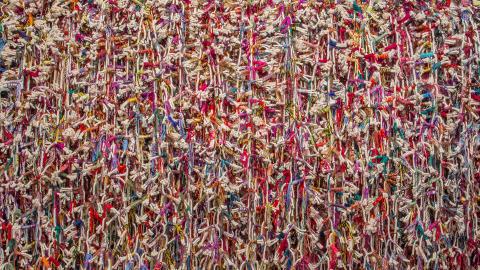 A work made of brightly coloured rope and wool arranged like a collage.