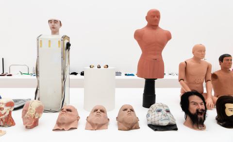 A photograph of various mannikins and masks in various styles, with a sense of uncanny valley.