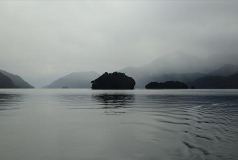 A small island set in a misty body of water.