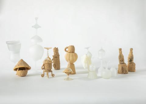A variety of glass and cork vessels in abstract shapes stand against a white background.