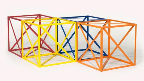 Four cubic structures, with one painted red, one yellow, one blue and one orange.
