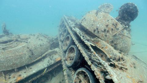 A photograph of the wreck of a tank underwater.