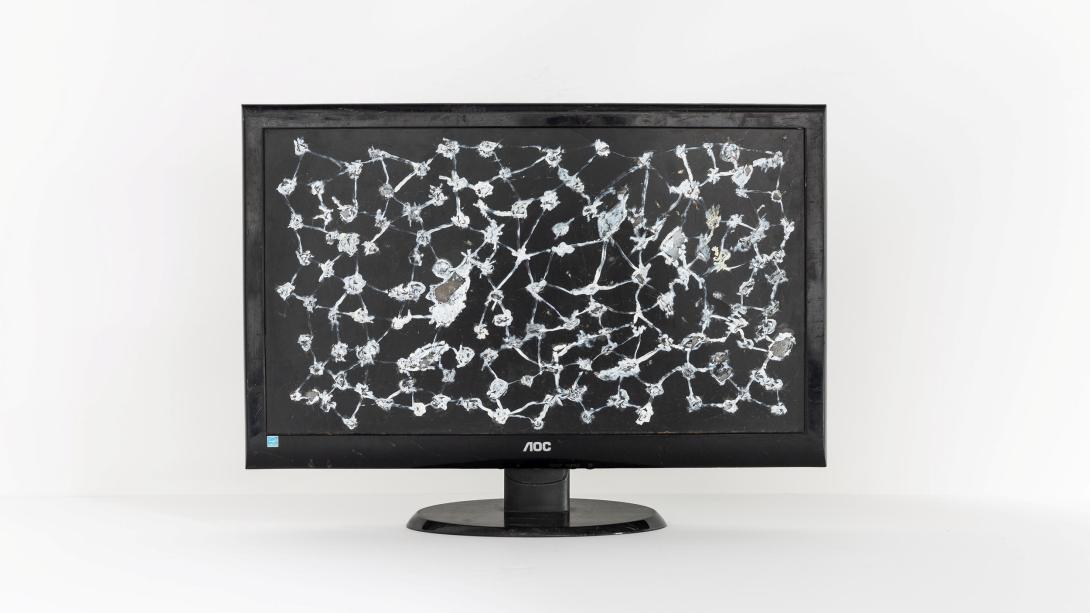 An abstract artwork that looks like a starry cosmos on a black background, painted onto a tv monitor.