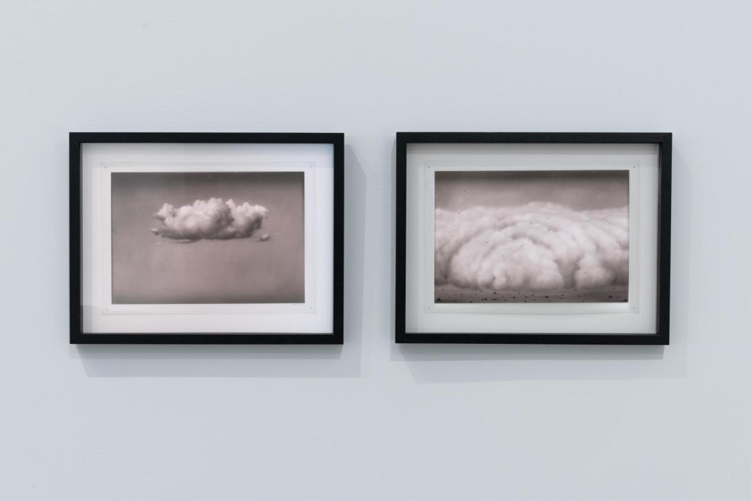 An installation view of two drawings of clouds, framed and placed on a gallery wall.
