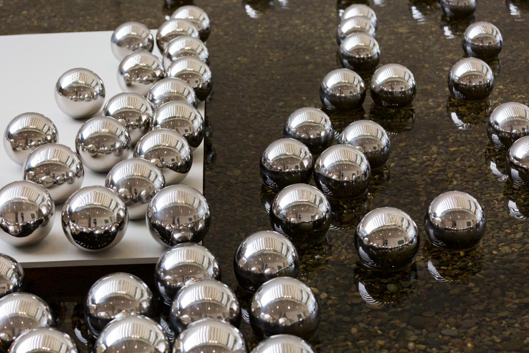 A photograph of mirrored balls floating in water.