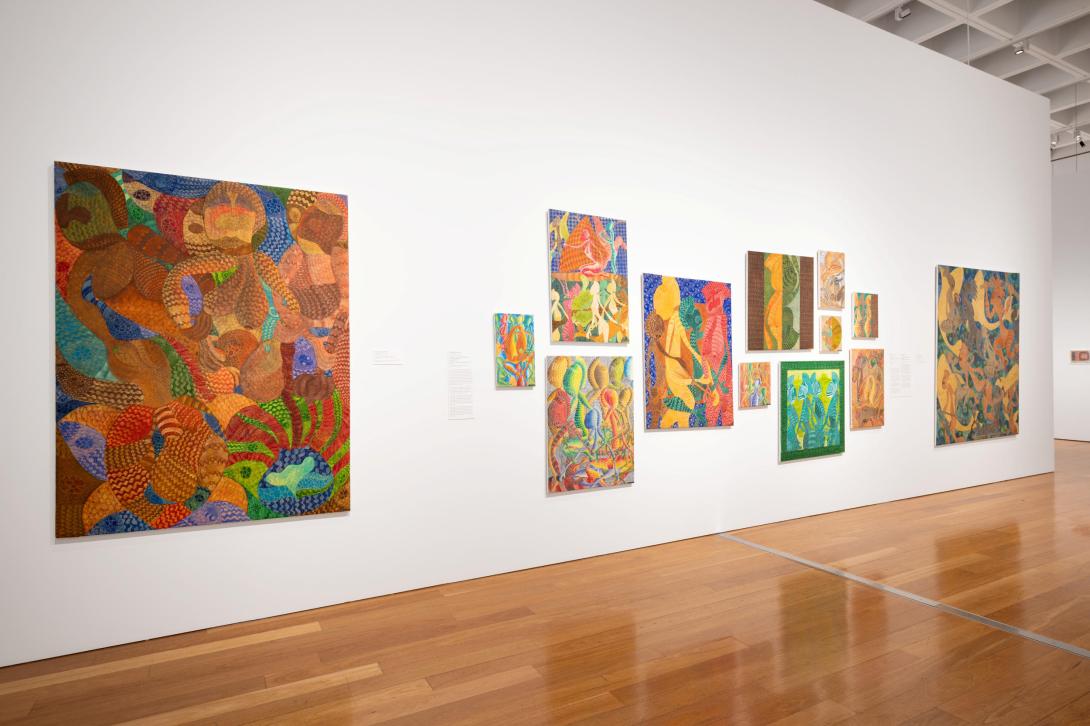 Colourful paintings installed on a white gallery wall