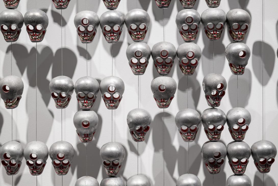A detail view of small metal skulls forming part of a larger installation