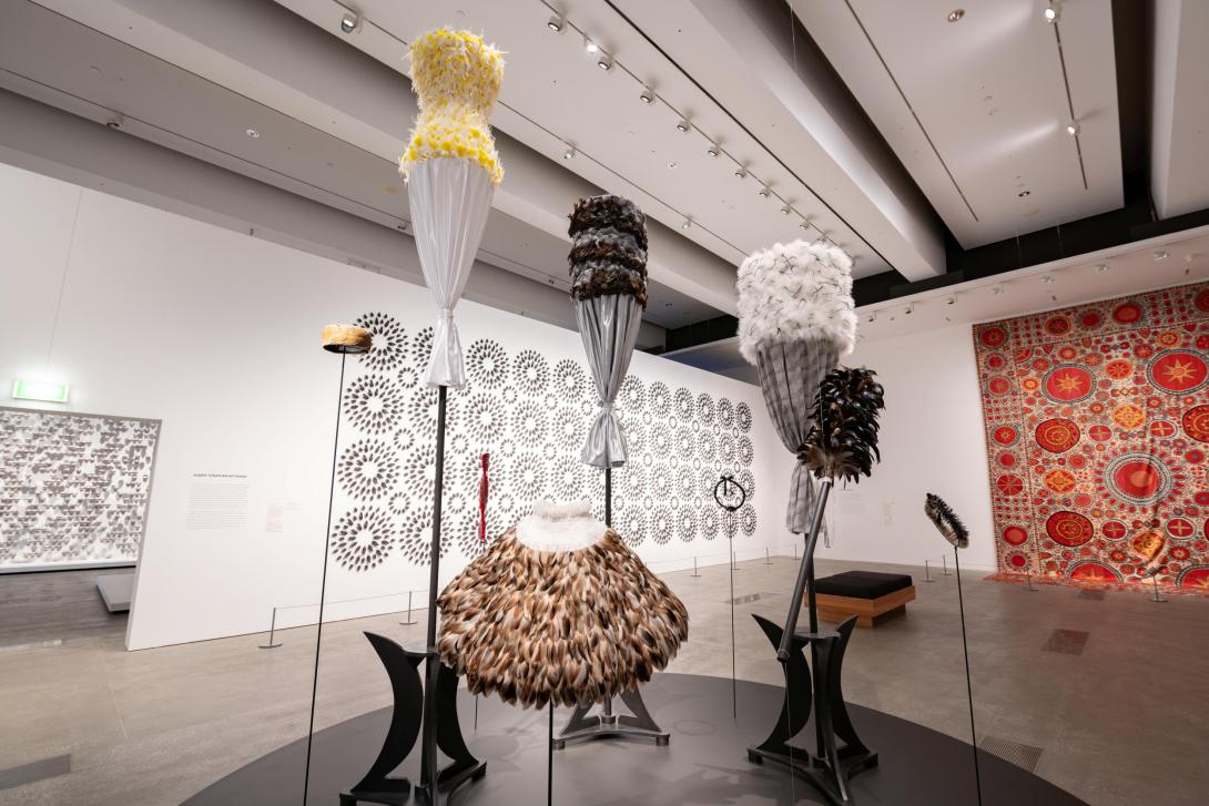 Textile works installed in the centre of a gallery space, with other artworks installed on walls behind