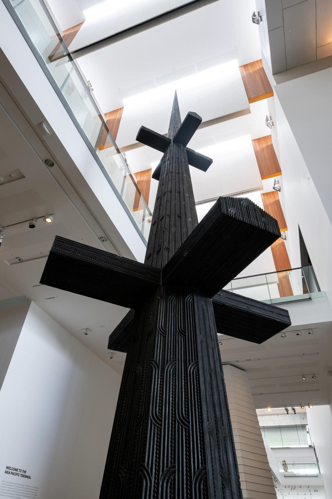 A tall sculptural work installed in a gallery foyer.