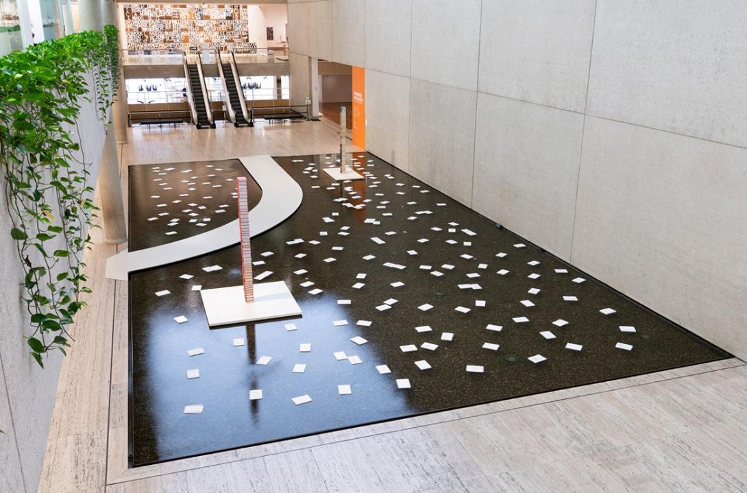 An installation view of the Queensland Art Gallery Watermall, with works that look like books floating on the water itself